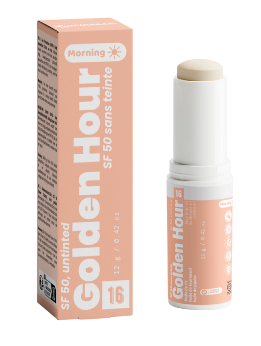 Packshot de Golden Hour n°16 de Luminesse Paris avec son étui pêche et son stick solaire SPF 50 sans teinte de 12 g. Le produit est présenté ouvert avec le stick beige visible, à côté de sa boîte ; la mention Morning et les huiles de riz, tournesol et jojoba figurent sur le packaging.