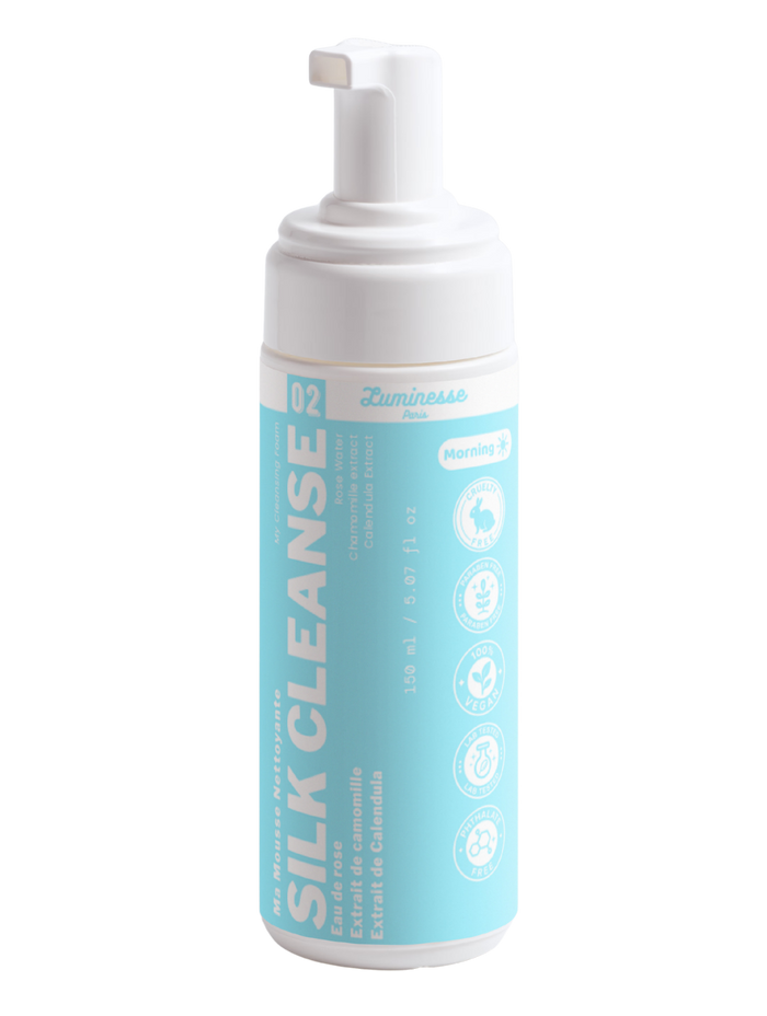 Packshot détouré de Silk Cleanse n°02 de Luminesse Paris, mousse nettoyante visage en flacon pompe blanc de 150 ml avec étiquette turquoise. Le packaging mentionne l’eau de rose, les extraits de camomille et de calendula ainsi que l’utilisation Morning.
