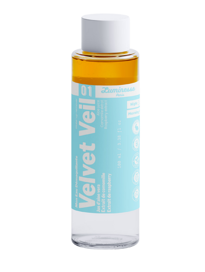 Packshot détouré de Velvet Veil n°01 de Luminesse Paris, eau démaquillante biphasée de 100 ml dans un flacon transparent à étiquette turquoise et bouchon blanc. Les deux phases du soin sont visibles, avec une phase ambrée au-dessus ; l’étiquette mentionne aloe vera, camomille et framboise ainsi que Morning et Night.